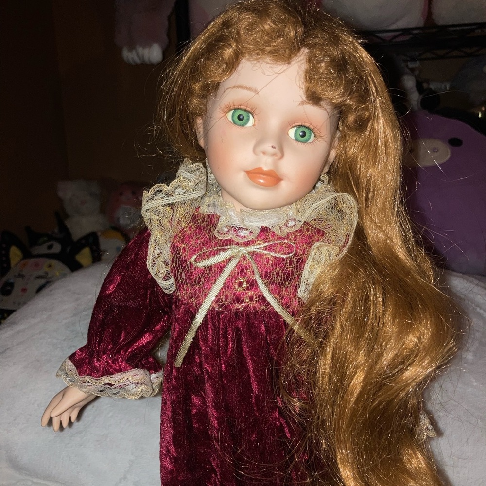 Porcelain doll, red wavy hair, green eyes, red dress